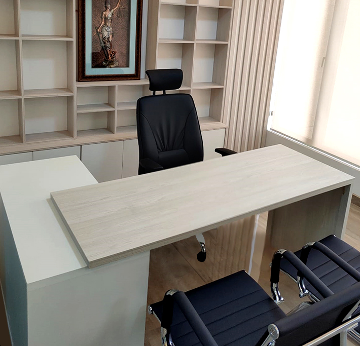 Oficina con escritorio, sillas y repisas.